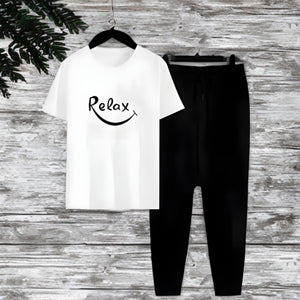 White t-shirt with 'Relax' text and black pants on a wooden surface